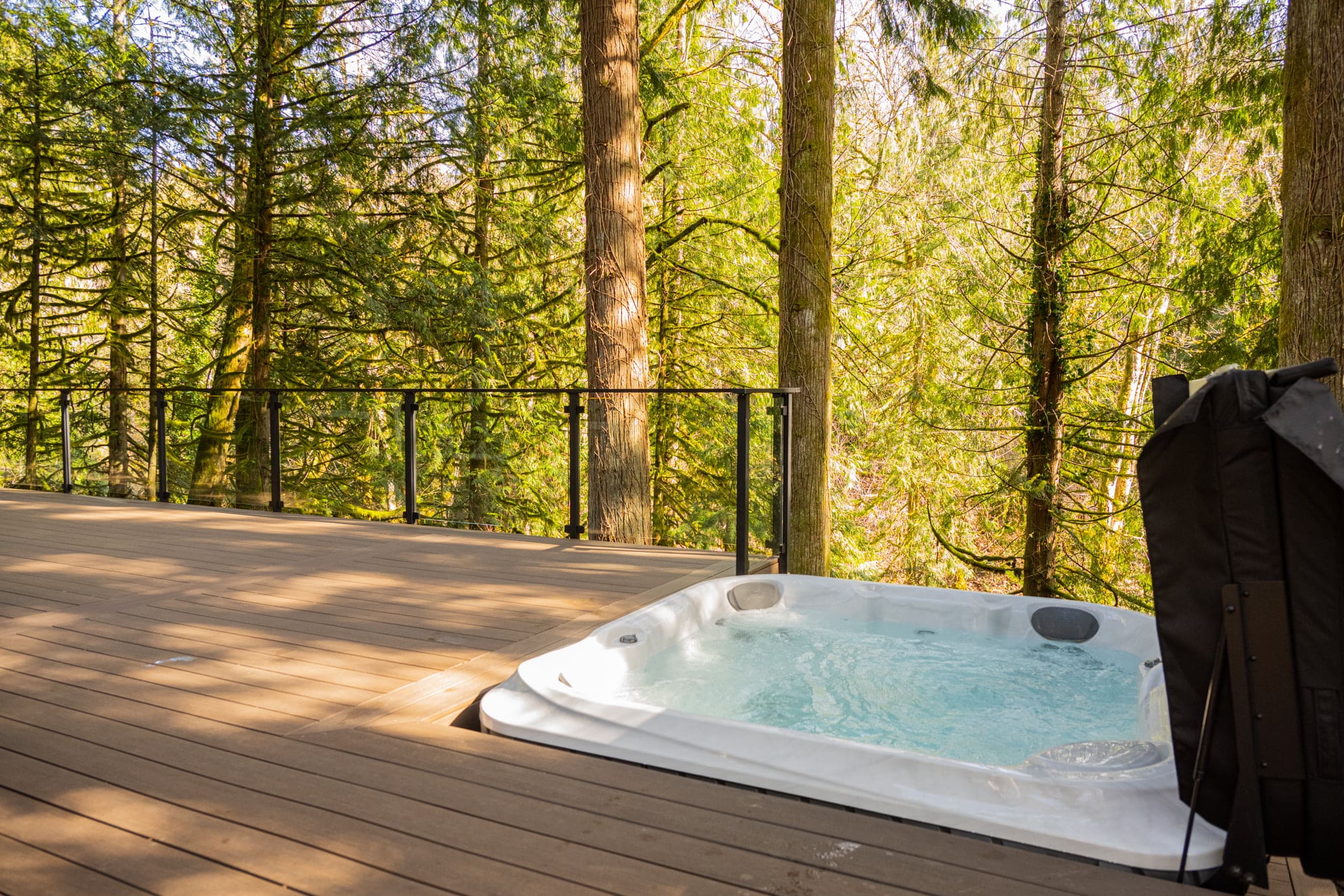 Hot tub on wooden deck overlooking forest