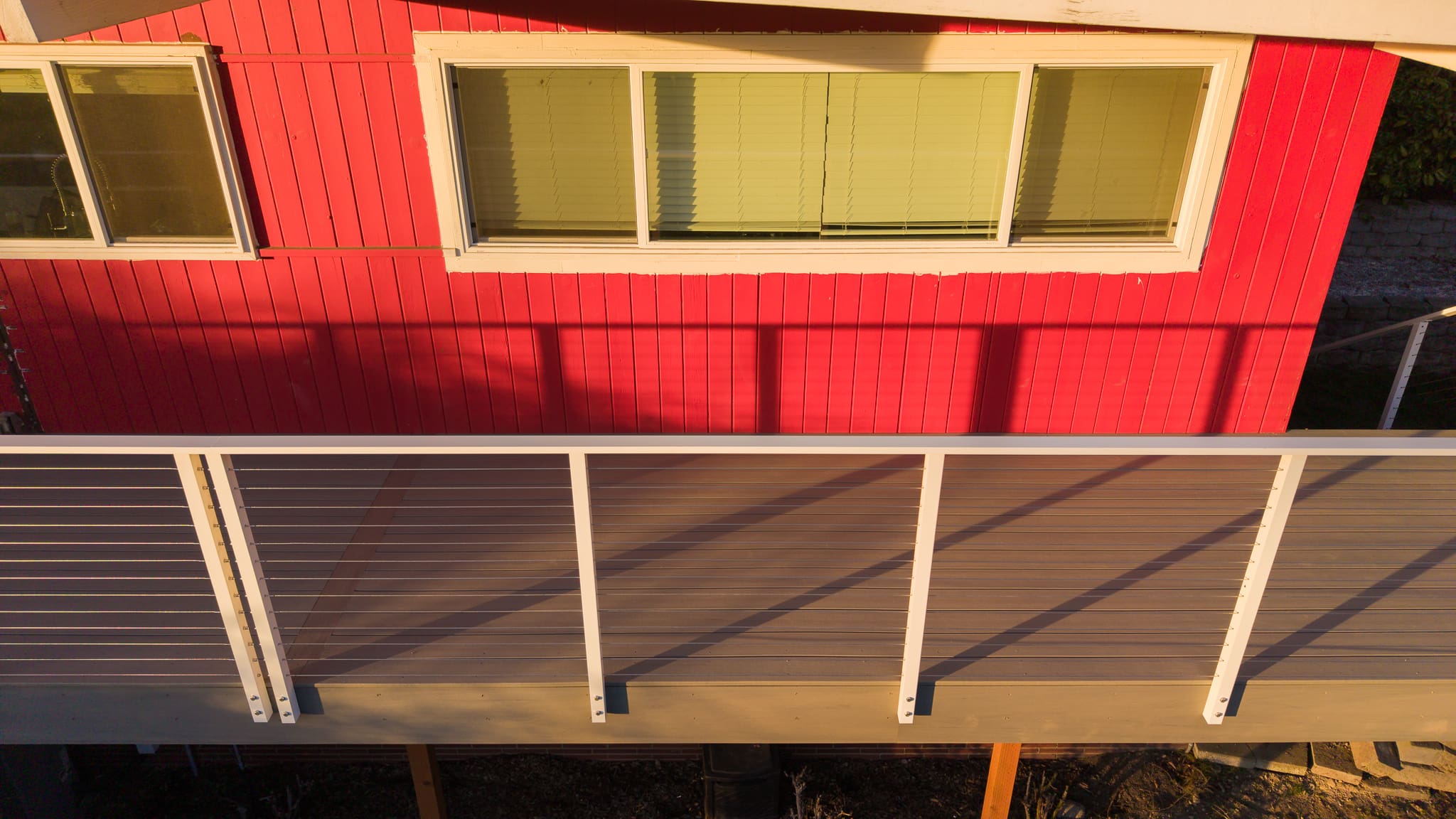 Red house exterior with deck and railing