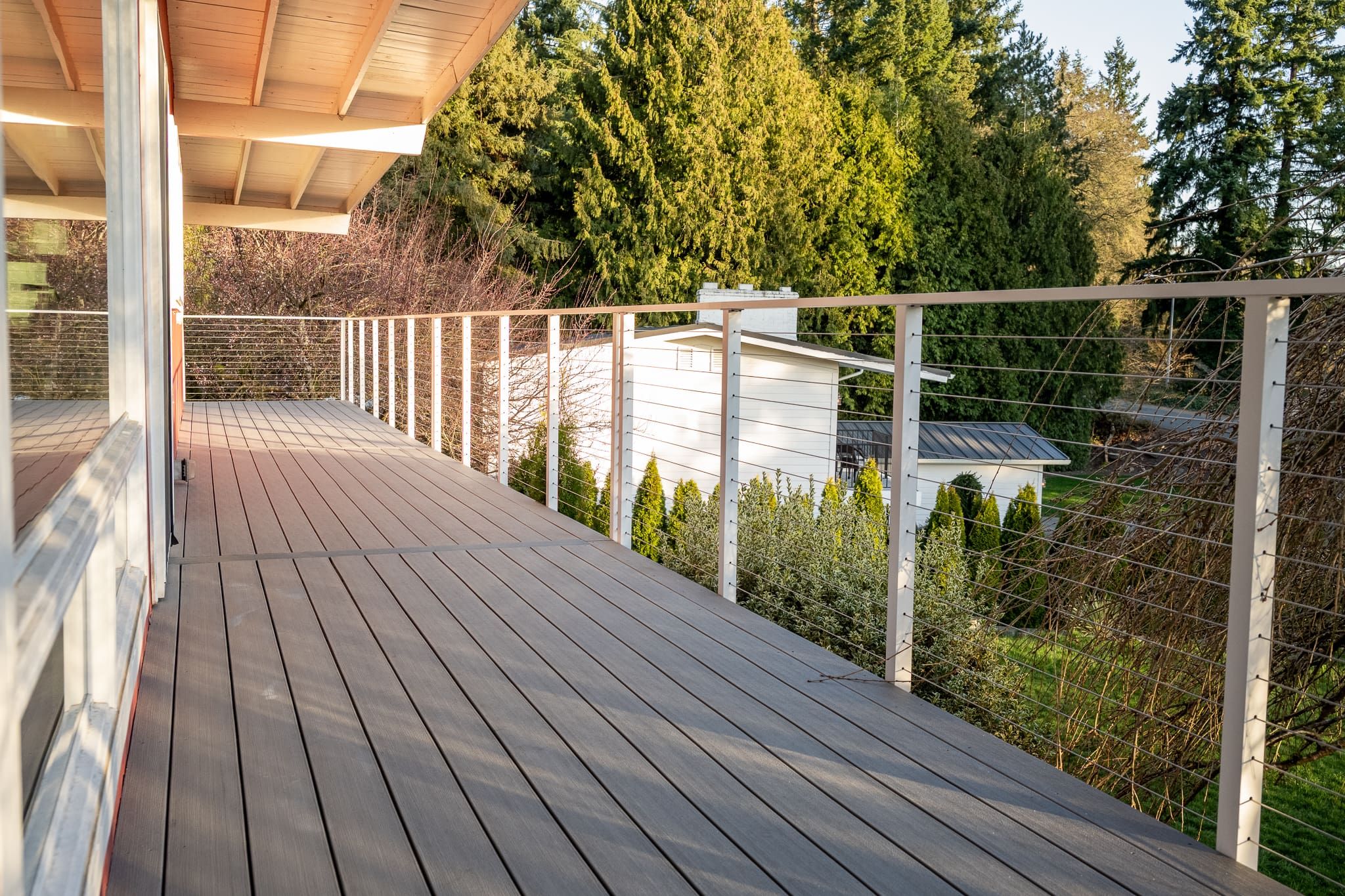 Modern balcony with cable railing and wooded view