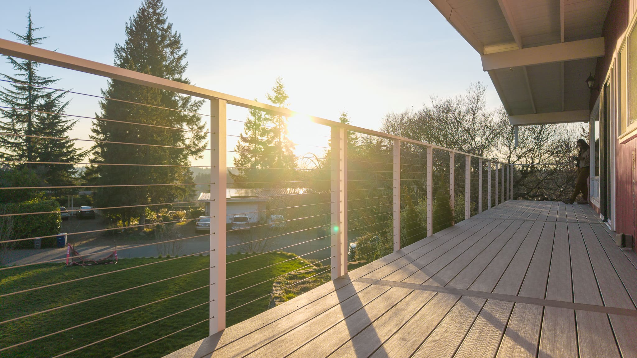 Sunset view from wooden balcony with cable railing