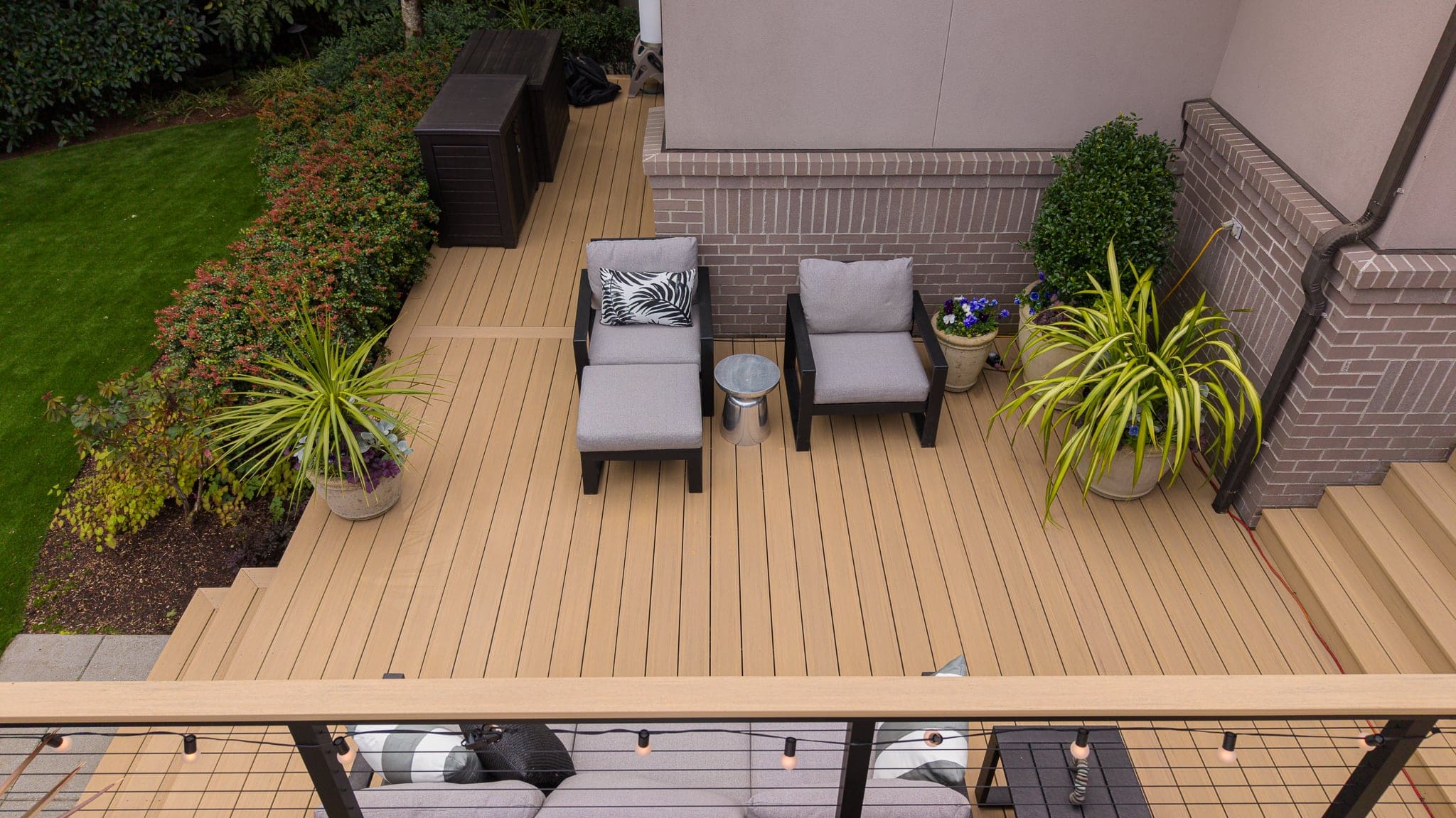 Modern wooden deck with chairs and potted plants