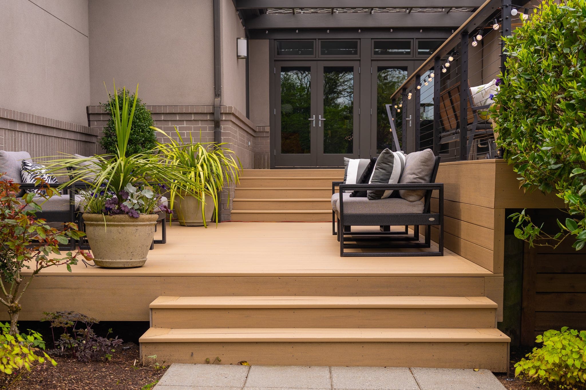 Modern backyard deck with seating and potted plants