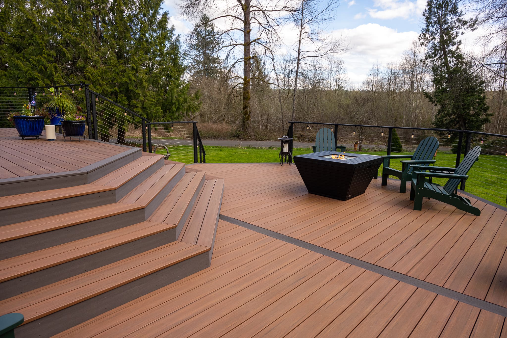 Spacious wooden deck with fire pit and chairs